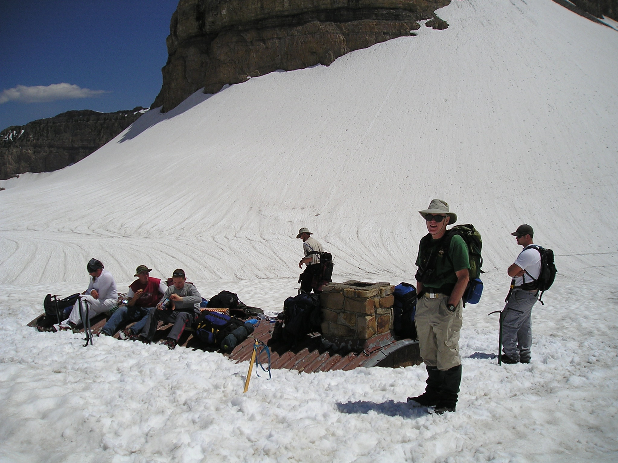 Two members of TERT sit on top of the Emerald Lake shelter, which is buried in snow
